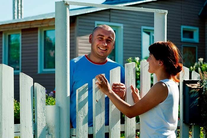 neighbors talk over fence